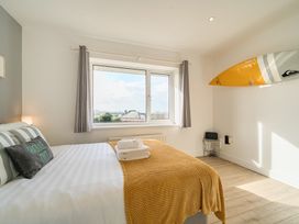 A bedroom with a bed and surfboard at Chi An Mor in Porth