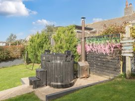 A hot tub with stove and greenery at Chi An Mor in Porth