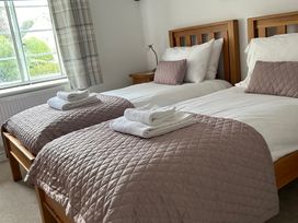 A bedroom with two beds at Bramble Cottage in Burton Bradstock