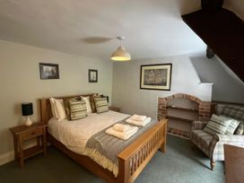 A bedroom with a bed and nightstand at Ivy Cottage in West Lulworth