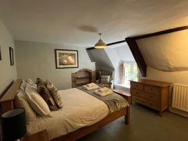 A bedroom with a bed and dresser at Ivy Cottage in West Lulworth