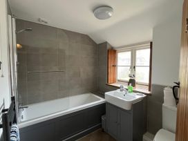 A bathroom with a bathtub and sink at Ivy Cottage in West Lulworth