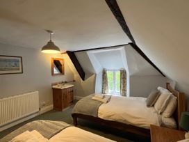 A bedroom with two beds and a dressing table at Ivy Cottage West Lulworth