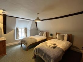 A bedroom with two single beds and a window at Ivy Cottage in West Lulworth