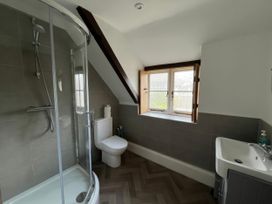 A bathroom with a shower, toilet, and sink at Ivy Cottage in West Lulworth
