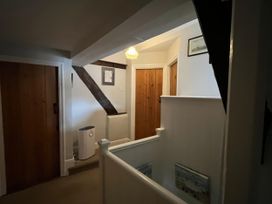 A hallway with doors and a staircase at Ivy Cottage in West Lulworth