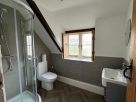 A bathroom with a shower, toilet, and sink at Ivy Cottage in West Lulworth