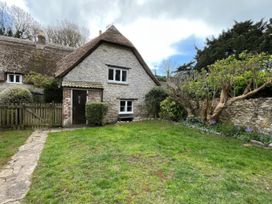 An outdoor area with a stone house and garden at Ivy Cottage in West Lulworth
