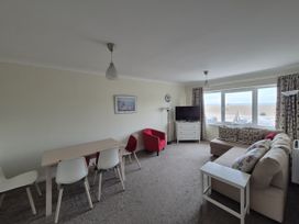 A living room with a sofa and dining area at Jurassic View West Bay