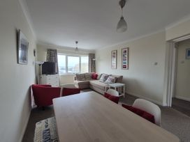 A living room with a sofa and dining set at Jurassic View in West Bay