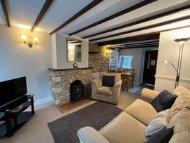 A living room with a sofa and television at Little Ivy in West Lulworth