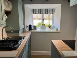 A kitchen with a sink and kitchen appliances at Little Ivy in West Lulworth