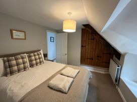 A bedroom with a bed and lamp at Little Ivy in West Lulworth