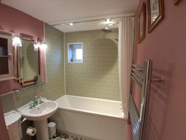 A bathroom with a bath, sink, and toilet at Little Retreat in Upwey