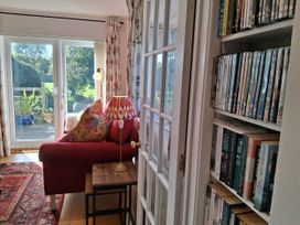 A living room with a sofa and a bookshelf at Little Retreat in Upwey