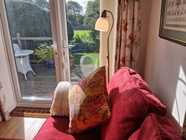 A living room with a sofa and plants at Little Retreat in Upwey