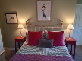 A bedroom with a bed and nightstands at Little Retreat in Upwey