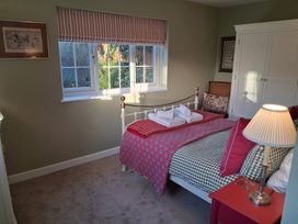 A bedroom with a bed and window at Little Retreat in Upwey