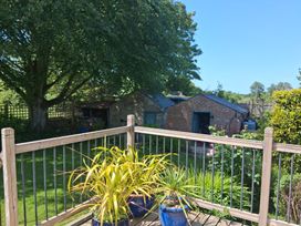 A garden with decking, plants and sheds at Little Retreat, Upwey