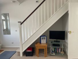 An indoor space featuring stairs, a television, and a table at Maisy Cottage in Weymouth
