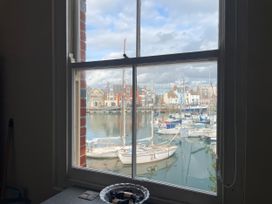 A view of boats in the water from a window at Mutiny House in Brewers Quay Harbour