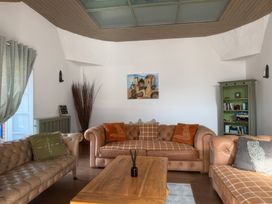 A living room with sofas, a coffee table, and a bookshelf at The Oast House in Brewers Quay Harbour