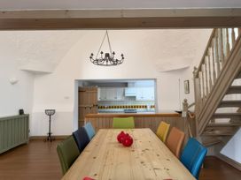 A dining room with a wooden table and colorful chairs at The Oast House in Brewers Quay Harbour