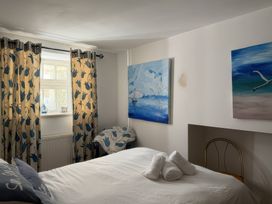 A bedroom with a bed and paintings on the wall at The Oast House in Brewers Quay Harbour