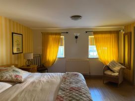 A bedroom with a bed, lamp, and chair at The Oast House in Brewers Quay Harbour