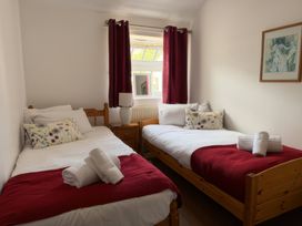 A bedroom with two single beds and a mirror at The Oast House in Brewers Quay Harbour