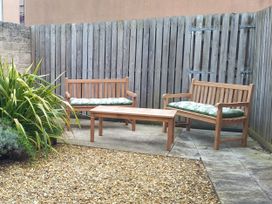 A garden with wooden benches and a coffee table at Olympic Cottage in Portland