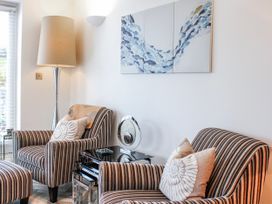 A living room with striped armchairs and a lamp at Estuary View in Kingsbridge