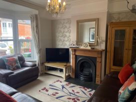 A living room with a television and sofa at Pedaller's Cottage in Weymouth