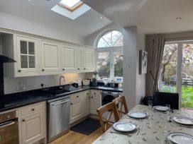 A kitchen with a dining table and chairs at Pedaller's Cottage in Weymouth