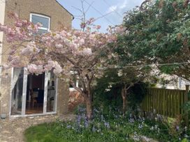 A garden with trees and flowers at Pedaller's Cottage in Weymouth