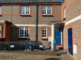 A brick house with blue door windows and a blue fence at Poppies Brewers Quay Harbour