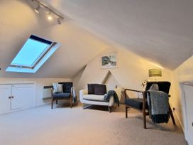 A loft with armchairs and a sofa at Quay Cottage in Weymouth