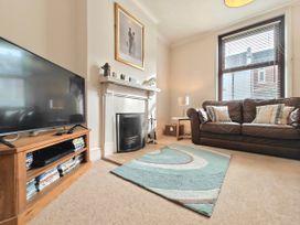A living room with a television and a sofa at Quay Cottage in Weymouth