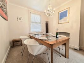 A dining room with a table and chairs at Quay Cottage in Weymouth