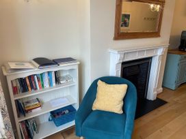 A living room with a bookshelf and blue chair at Safe Harbour in Brewers Quay harbour