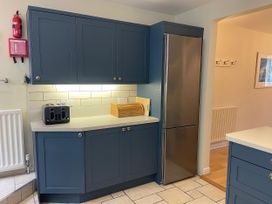 A kitchen with cabinets, a toaster, and a refrigerator at Safe Harbour in Brewers Quay harbour