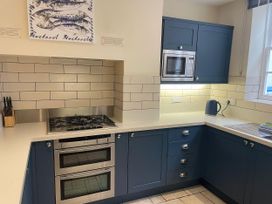A kitchen with appliances and cabinetry at Safe Harbour Brewers Quay harbour