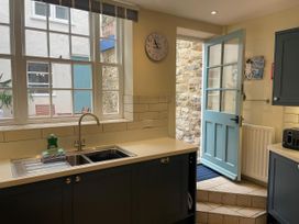 A kitchen with a sink and door to the outside at Safe Harbour in Brewers Quay harbour
