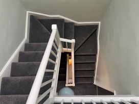 A staircase with a handrail and light fixture at Safe Harbour in Brewers Quay harbour