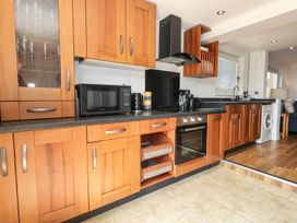 A kitchen with cabinets appliances and sink at Tides Corner in Bowleaze