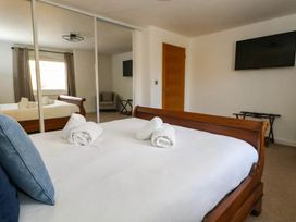 A bedroom with a bed and television at Tides Corner in Bowleaze