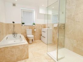 A bathroom with a bathtub, toilet, sink, and shower at Tides Corner in Bowleaze