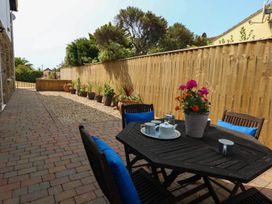 An outdoor seating area with a table and chairs at Tides Corner Bowleaze