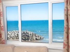 A view of the ocean and rocks through a window at Weymouth Bay Apartment C in Greenhill