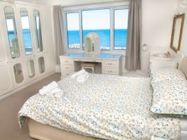 A bedroom with a bed and wardrobe at Weymouth Bay Apartment C in Greenhill